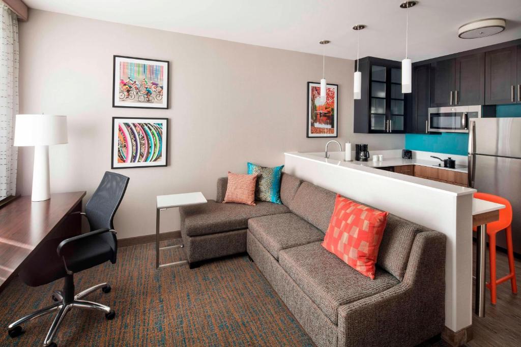a living room with a couch and a kitchen at Residence Inn by Marriott Boston Watertown in Watertown