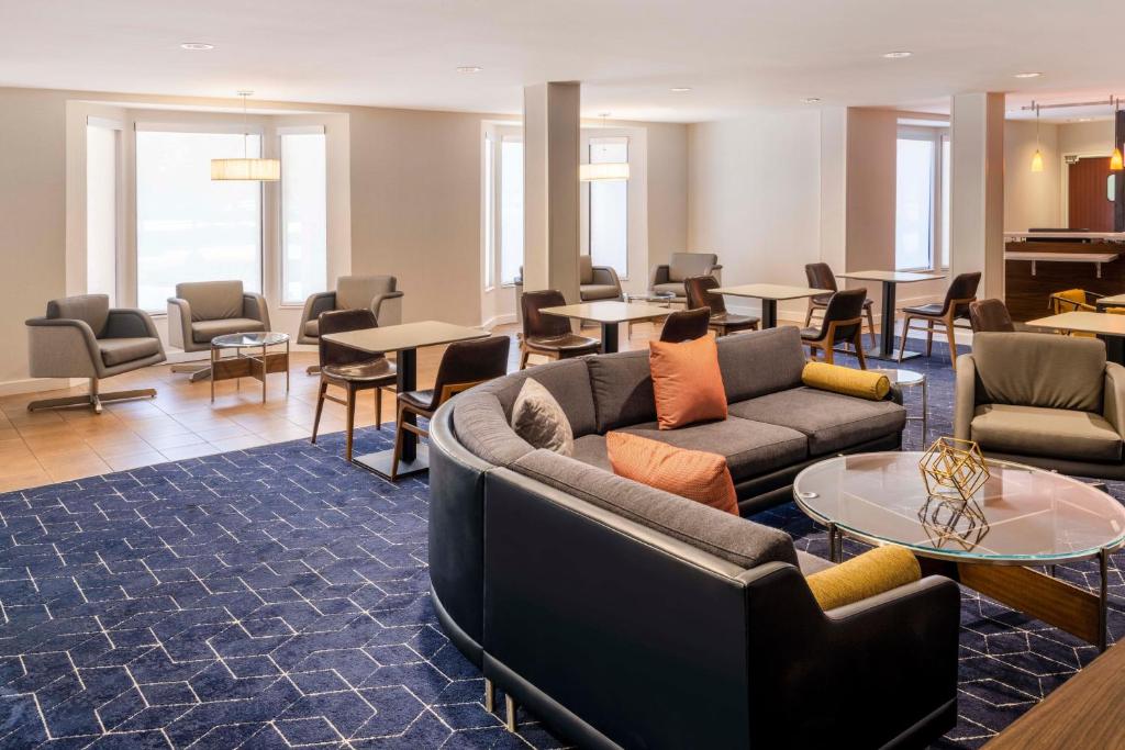 a living room with couches and tables and chairs at Courtyard Denver Southwest/Lakewood in Lakewood