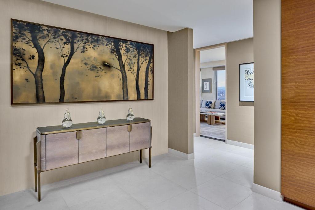 a hallway with a painting of trees on the wall at The St. Regis San Francisco in San Francisco