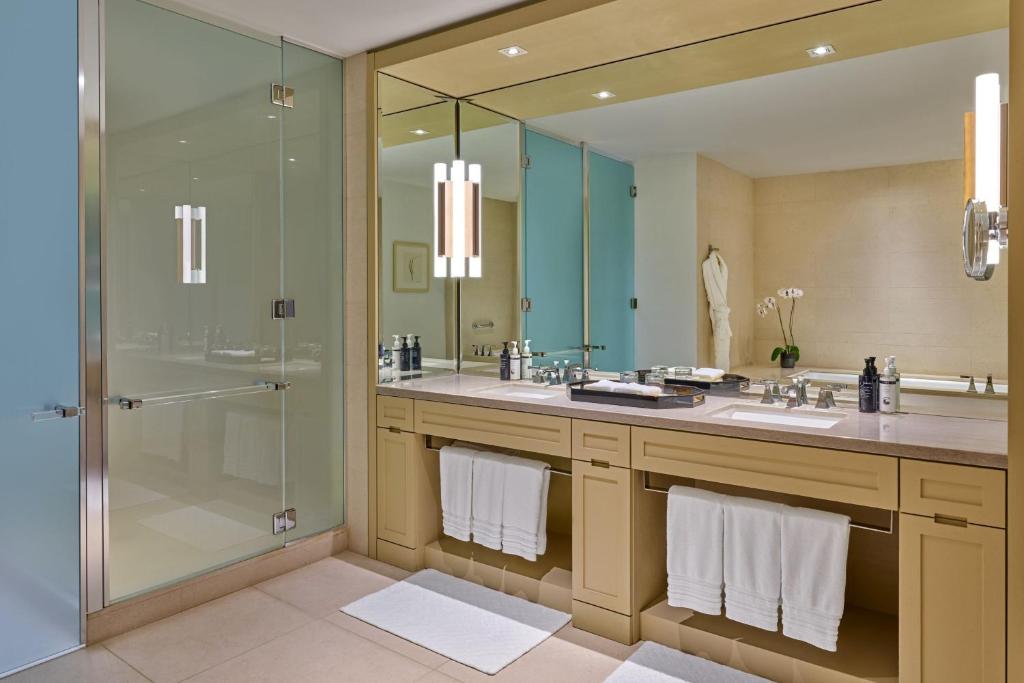 a bathroom with two sinks and a glass shower at The St. Regis San Francisco in San Francisco