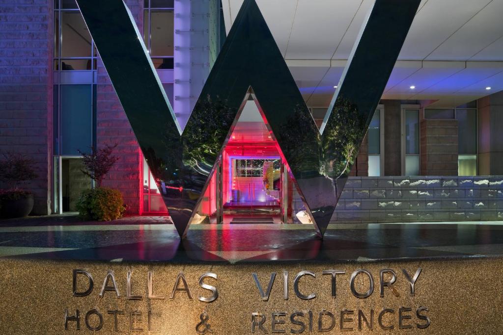 un cartel frente a un edificio con un hotel de Miami Victory en W Dallas - Victory, en Dallas