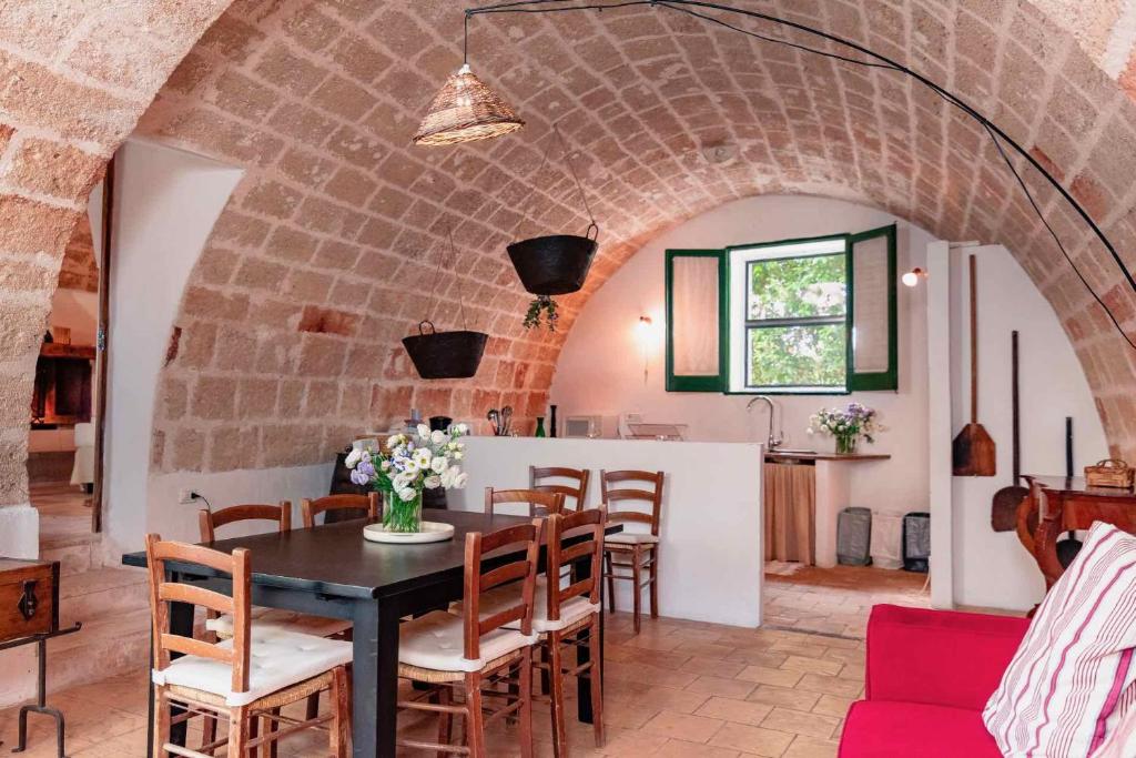 a dining room with a table and chairs at Masseria Spina Resort in Monopoli