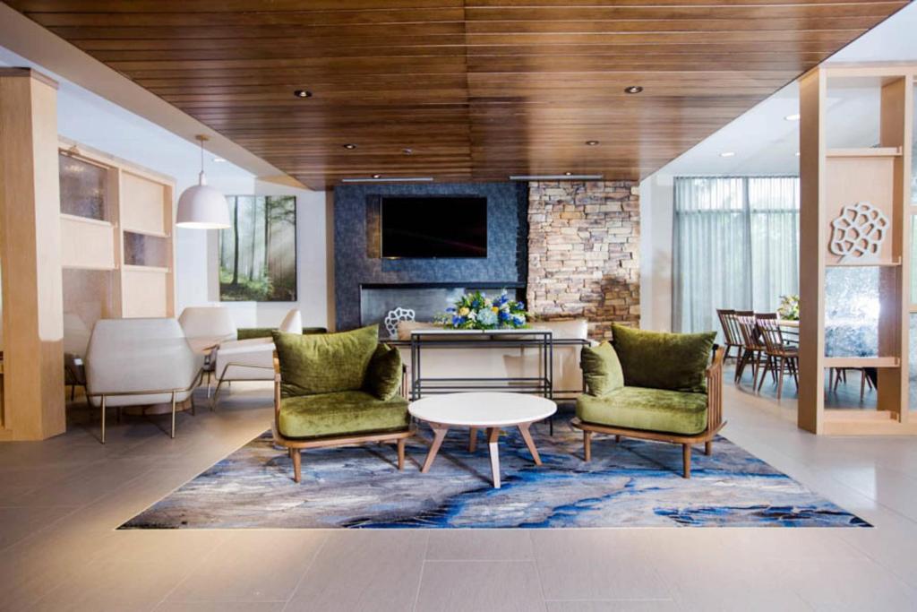 a living room with two chairs and a table and a dining room at Fairfield Inn & Suites by Marriott Philadelphia Broomall/Newtown Square in Broomall