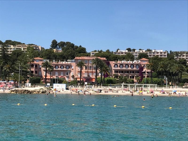une plage avec un groupe de personnes dans l'eau dans l'établissement Appartement vue mer, à Bandol