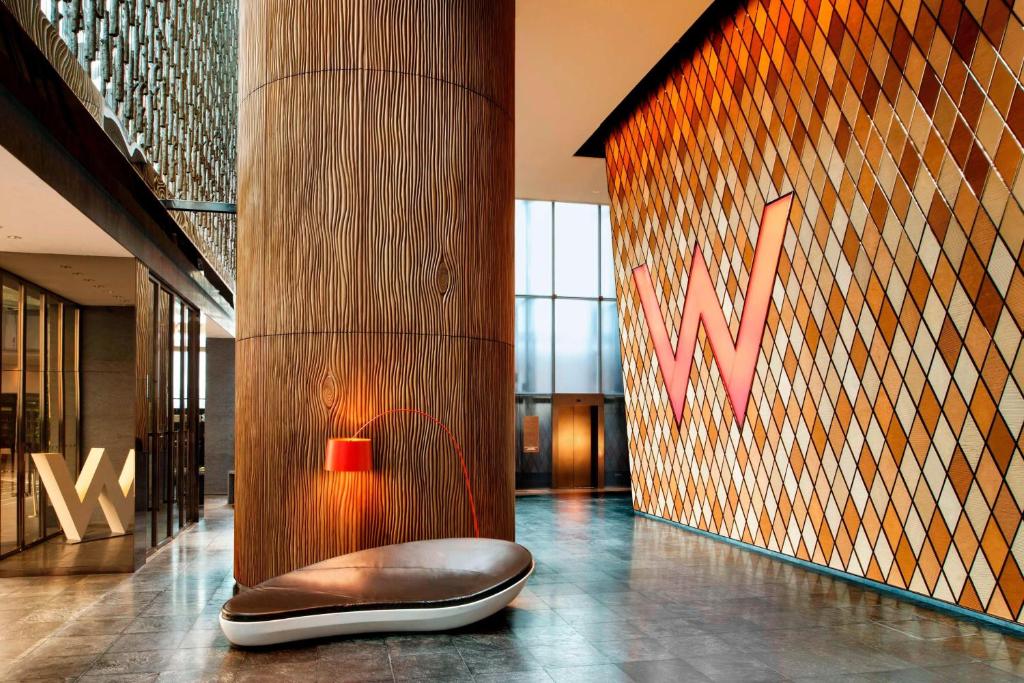 a lobby with a chair in front of a wall at W Hong Kong in Hong Kong