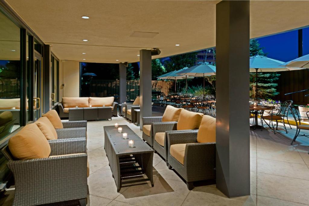 un patio con sofás, mesa y sillas en Denver Marriott South at Park Meadows, en Lone Tree