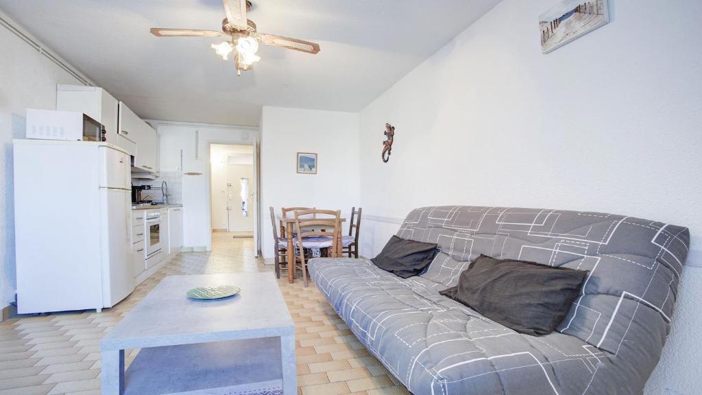 een woonkamer met een bank en een tafel bij Le Cosmos - 15C - Appart spacieux- 4 pers in Cap d'Agde