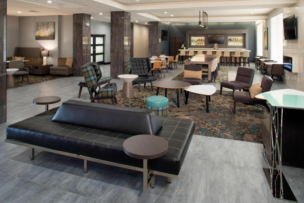 um átrio com um sofá, cadeiras e mesas em Residence Inn by Marriott Tulsa Downtown em Tulsa