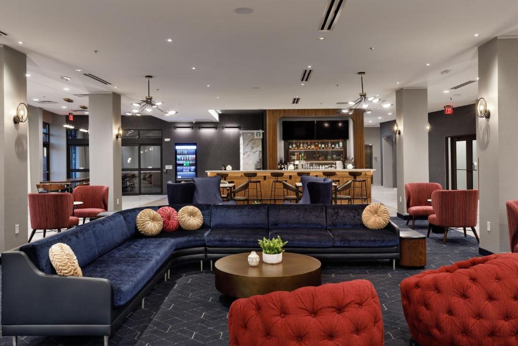 a lobby with a blue couch and chairs and a bar at Courtyard by Marriott Richmond Scott's Addition in Richmond