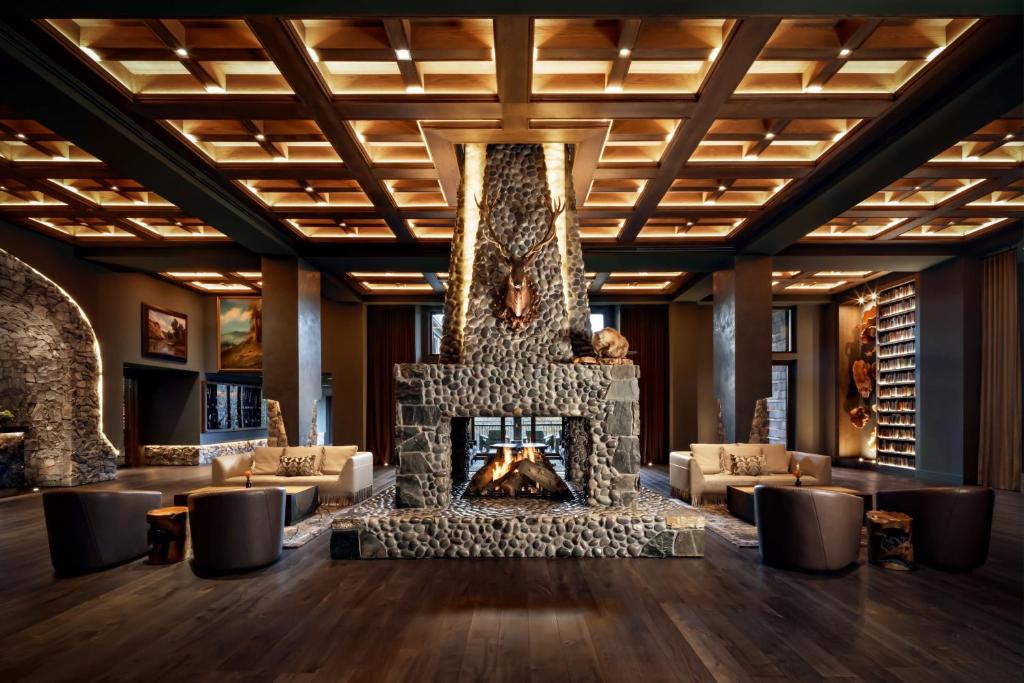a lobby with a stone fireplace and couches at Grand Bohemian Lodge Greenville, Autograph Collection in Greenville
