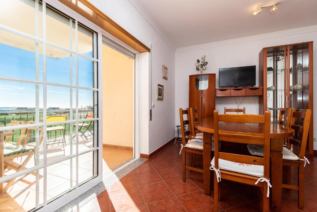 a dining room with a table and a balcony at Beach Front View Armacao de Pera Flat in Armação de Pêra