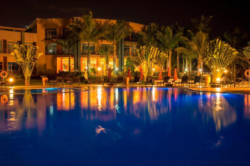 a swimming pool at night with a hotel at Protea Hotel by Marriott Entebbe in Entebbe