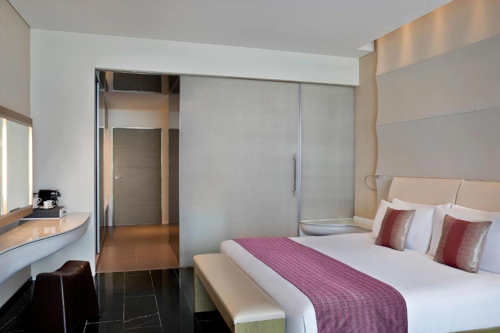 a bedroom with a large white bed with a purple blanket at W Abu Dhabi - Yas Island in Abu Dhabi
