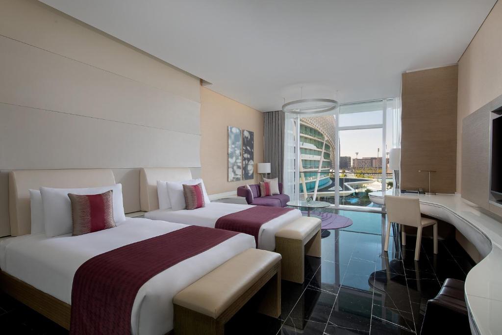 a hotel room with two beds and a balcony at W Abu Dhabi - Yas Island in Abu Dhabi