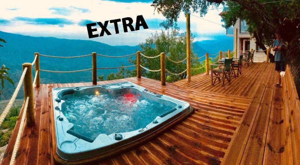 a hot tub on a wooden deck with a table and chairs at AlmondHouse Suites with Fireplace - ADULTS ONLY in Arachova