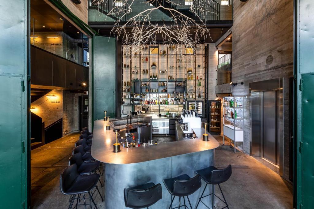 a bar with black chairs and a large counter at Boutique Hotel Herman K in Copenhagen