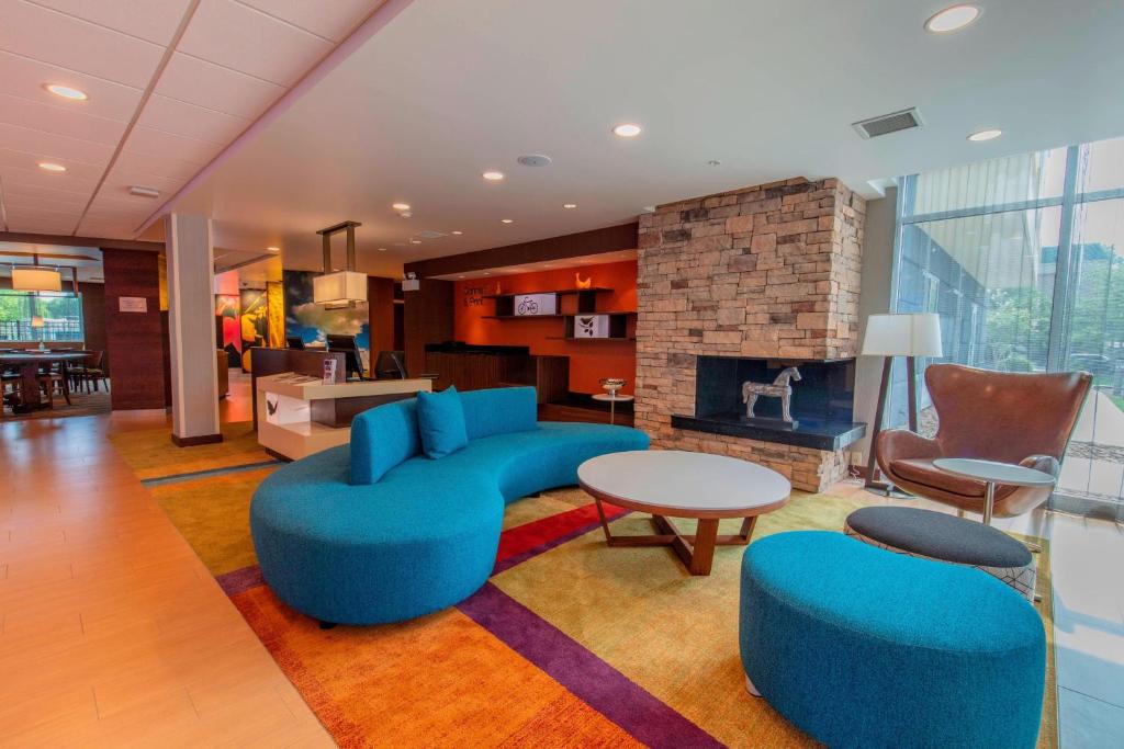 a living room with a blue couch and a fireplace at Fairfield Inn & Suites by Marriott Atlanta Woodstock in Woodstock
