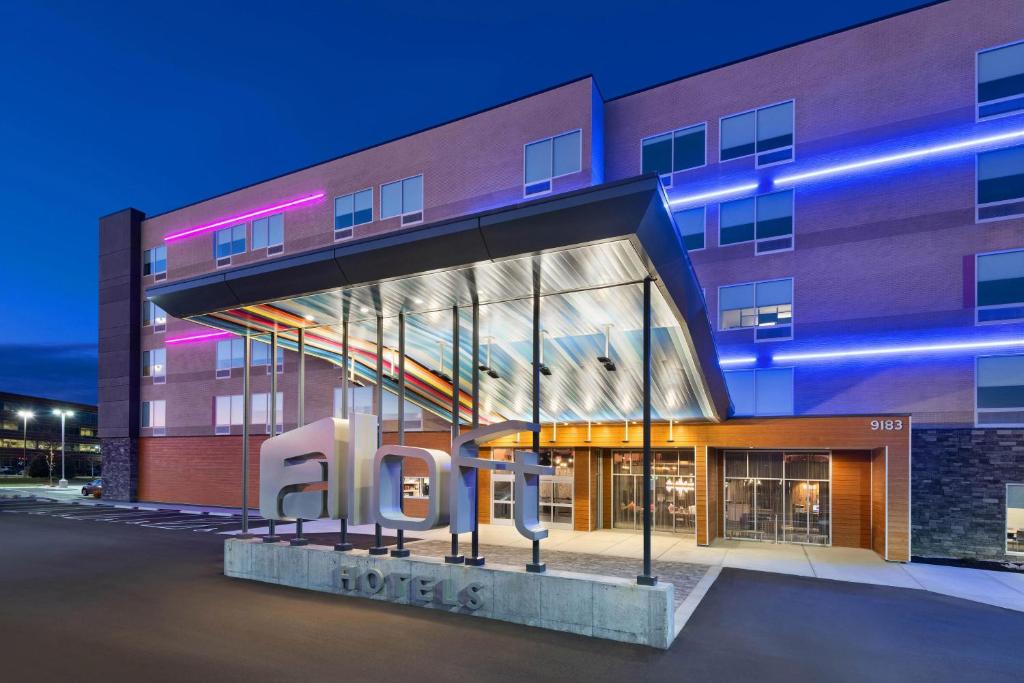 a building with a large sign in front of it at Aloft Cincinnati West Chester in West Chester