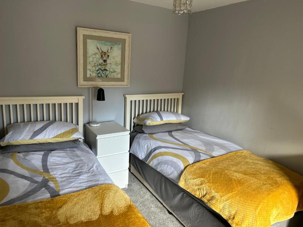 two beds sitting next to each other in a bedroom at Mews Cottage in Appleby