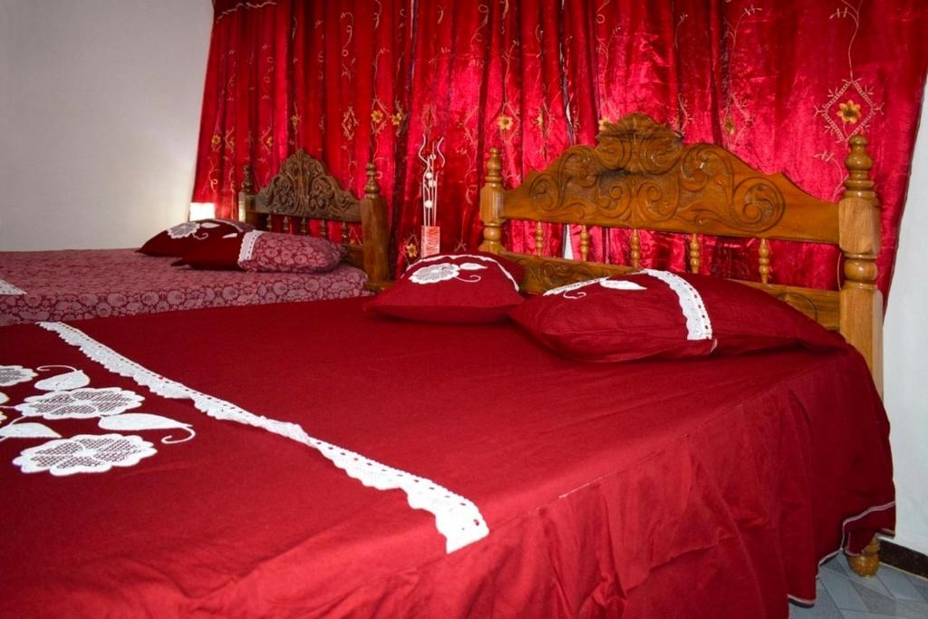 a bedroom with two red beds with red curtains at Casa colonial Villa Victoria Appartement 3 in Trinidad