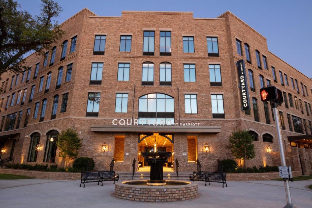 un gran edificio de ladrillo con una fuente frente a él en Courtyard by Marriott Thomasville Downtown, en Thomasville