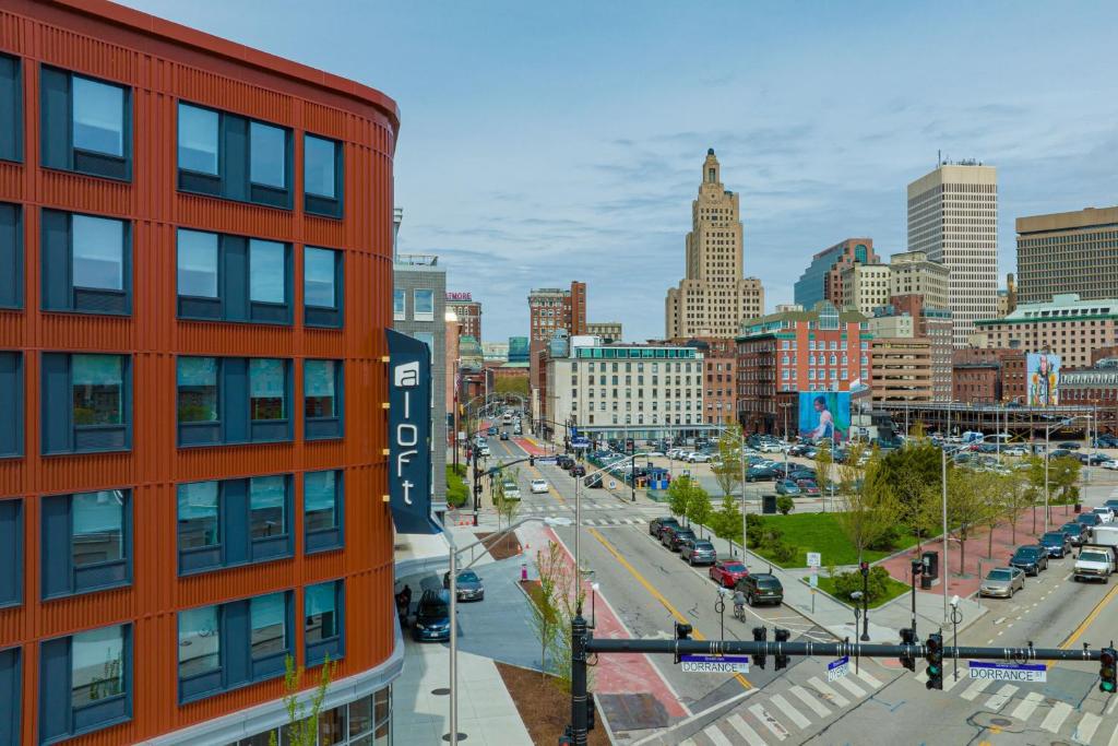 a city skyline with a red building and a street at Aloft Providence Downtown in Providence