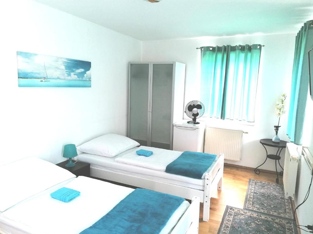 um pequeno quarto com duas camas e cortinas azuis em Favoriten-Rooms em Viena