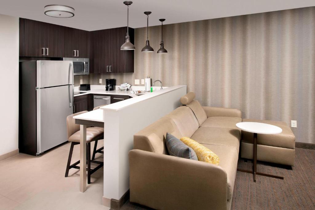 a kitchen and living room with a couch and a table at Residence Inn by Marriott Tampa Wesley Chapel in Wesley Chapel