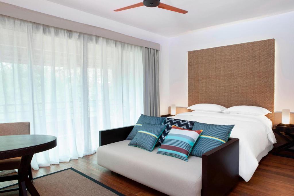 Rúm í herbergi á Sheraton New Caledonia Deva Spa & Golf Resort