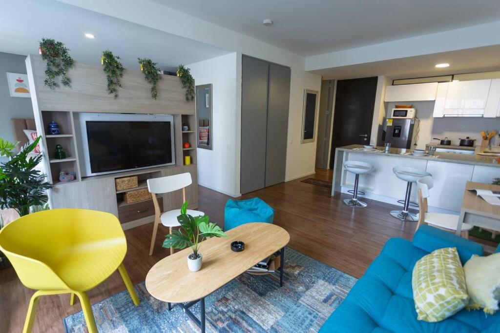 a living room with a blue couch and a table at Acogedor loft en Centro Internacional de Bogotá in Bogotá