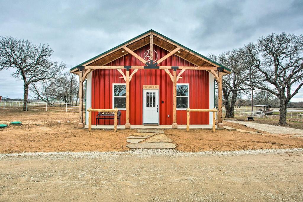 un hangar rouge avec une porte blanche dans un champ dans l'établissement Dog-Friendly Texas Ranch with Patio, Horses On-Site, à Aubrey