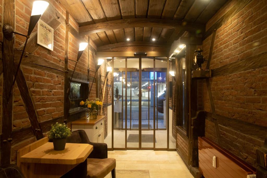 a living room with a table and a brick wall at Hotel Stadtkrug in Weiden