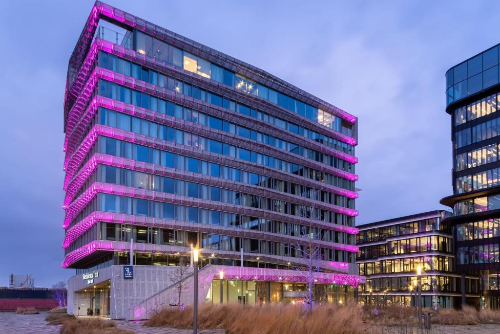 a tall building with pink lights on it at Moxy Amsterdam Houthavens in Amsterdam