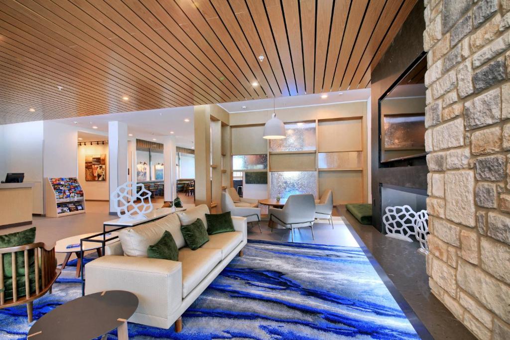 Fairfield Inn & Suites by Marriott Dallas Cedar Hill في سيدار هيل: غرفة معيشة مع أريكة وجدار حجري