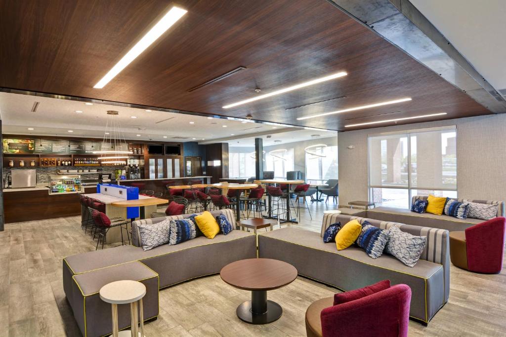 a lobby with couches and tables and a restaurant at Courtyard by Marriott Long Island Islip/Courthouse Complex in Central Islip