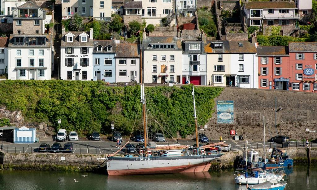 a boat is docked in the water in a city at Harbour View in Brixham