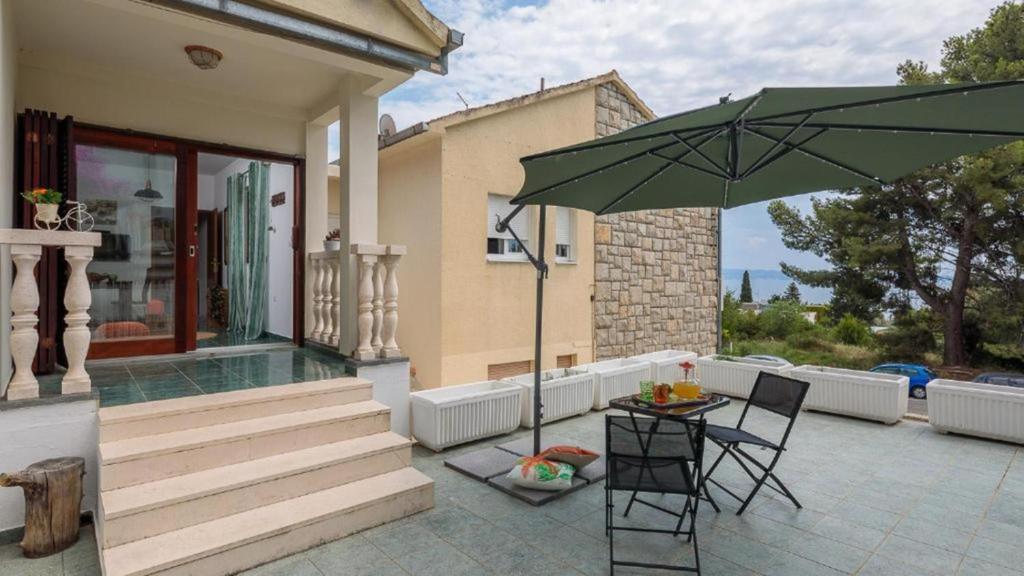 a patio with a table and a green umbrella at "NM" Luxury apartments in Split