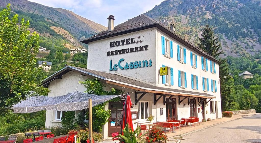 a building with a sign on the side of it at Hôtel Le Cassini in Le Freney-dʼOisans