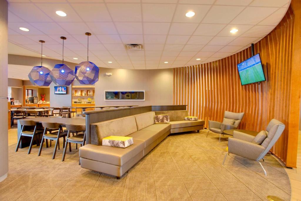 a living room with a couch and a dining room at SpringHill Suites by Marriott Lawrence Downtown in Lawrence