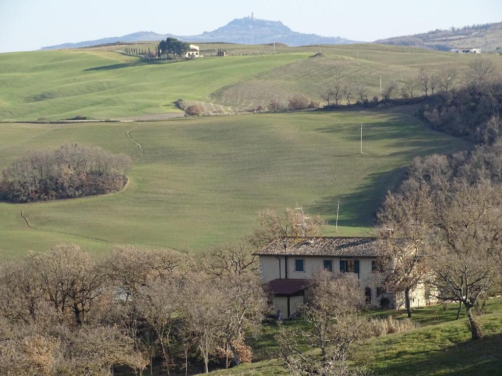 una casa en medio de un campo verde en Podere Travagliola, en Castiglione dʼOrcia