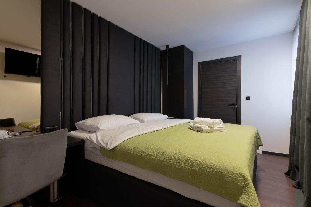 sypialnia z dużym łóżkiem i zielonym kocem w obiekcie City Premium Rooms Old town w mieście Zadar