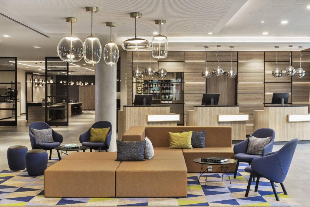 a lobby of a hotel with a couch and chairs at Courtyard by Marriott Hamburg City in Hamburg