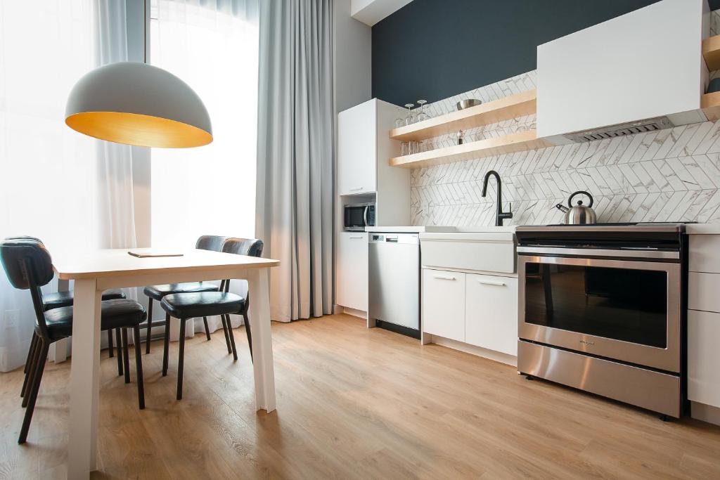 a kitchen with a table and a table and chairs at Les Lofts Charest - Par Les Lofts Vieux-Québec in Quebec City