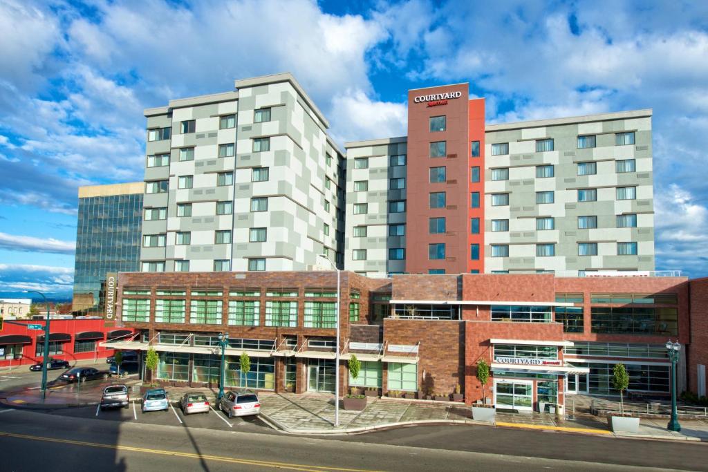 un gran edificio con coches estacionados en un estacionamiento en Courtyard by Marriott Seattle Everett Downtown en Everett