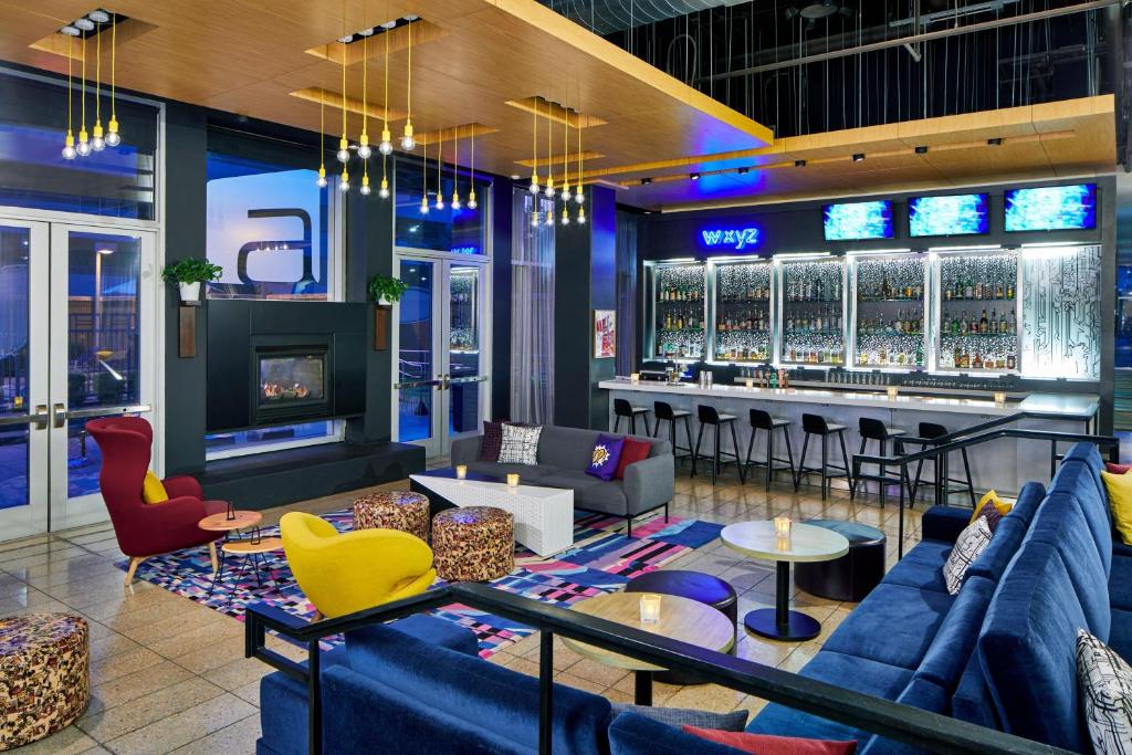 a bar with blue couches and chairs and a bar at Aloft Austin at The Domain in Austin