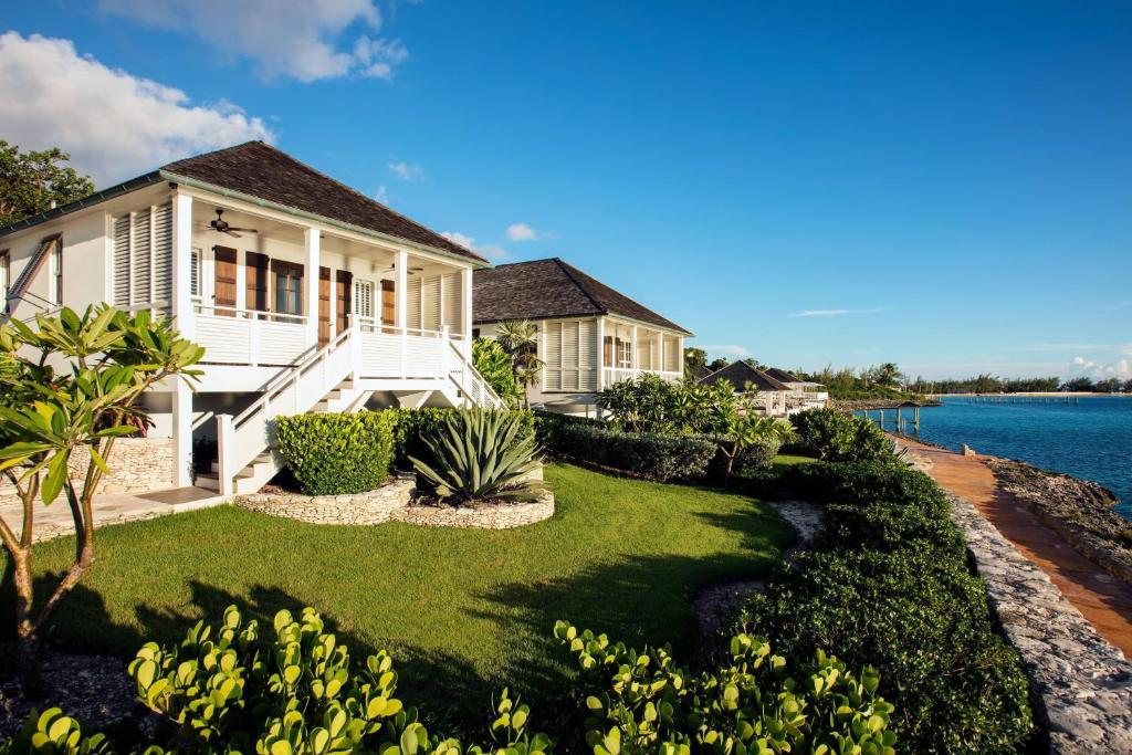 a house with a yard next to the water at French Leave Resort, Autograph Collection in Governorʼs Harbour