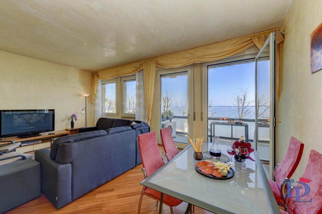 una sala de estar con una mesa y un sofá en Marriott Charming on the Lake Apartment DesenzanoLoft Official Partner Homes & Villas by Marriott Bonvoy, en Desenzano del Garda