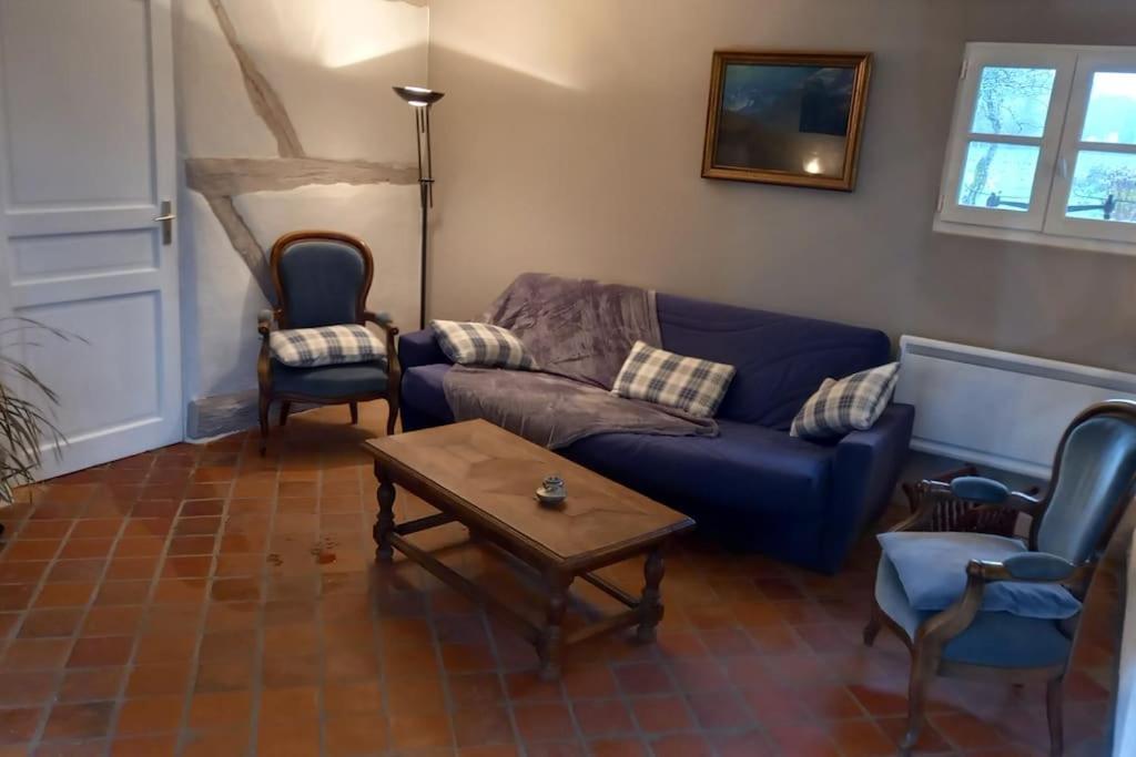 een woonkamer met een blauwe bank en 2 stoelen bij le havre de paix in Devay