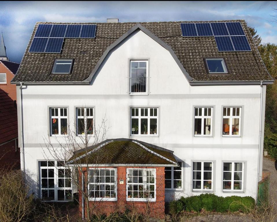 a white house with solar panels on its roof at Luxuriöses Loft mit schönem Blick in Tremsbüttel