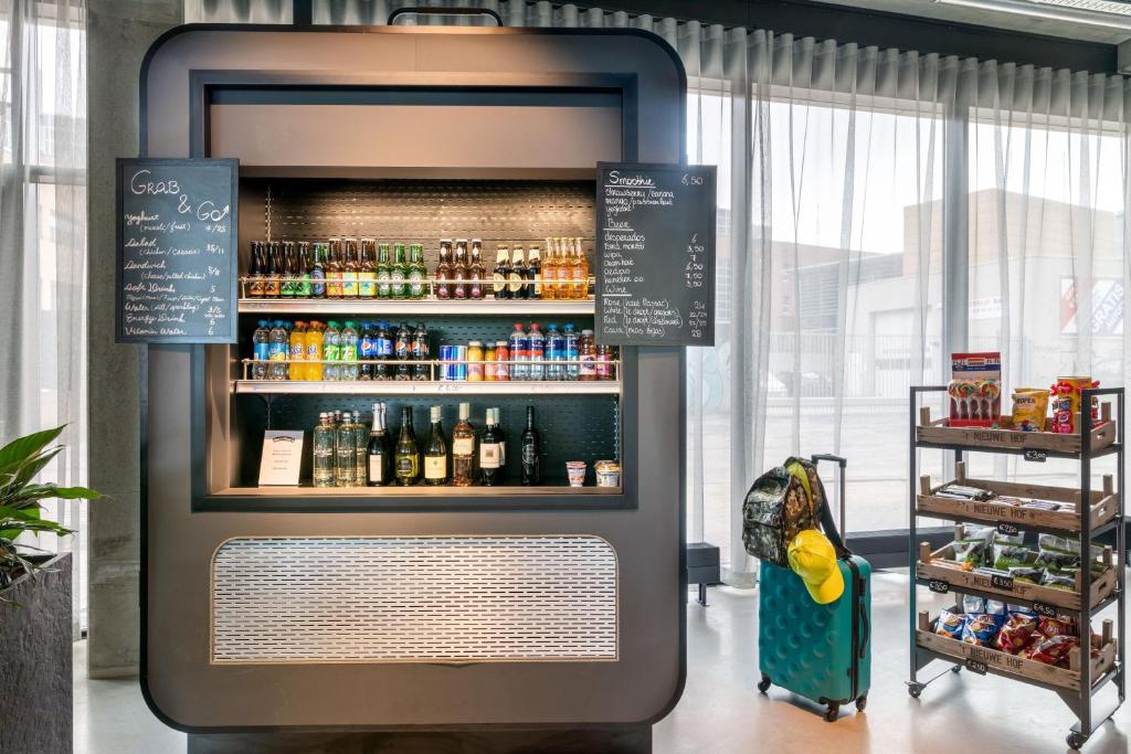 a drink cooler in a store with a lot of drinks at Moxy Berlin Airport in Schönefeld